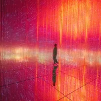 Woman in room installation with orange glowing lights