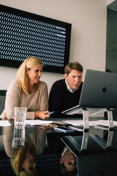 Gründer und Geschäftsführerin vor Laptop im Büro